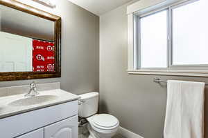 Bathroom featuring a textured ceiling, vanity, and toilet