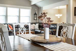 Dining area with lofted ceiling with beams and a chandelier