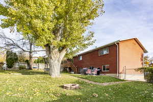 Back of house featuring a yard, an outdoor fire pit, and a wooden deck