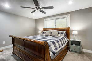 Bedroom featuring carpet flooring, ceiling fan, and a textured ceiling