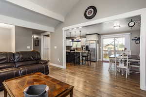 Living room with wood-type flooring, lofted ceiling, a textured ceiling, and a wealth of natural light