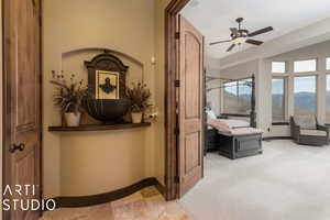 Carpeted bedroom with a mountain view and ceiling fan