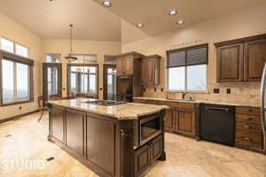 Kitchen featuring black appliances, a center island, a healthy amount of sunlight, and backsplash