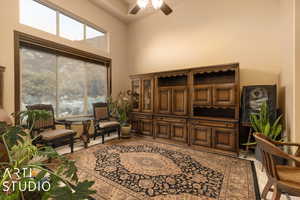 Living area with ceiling fan and a high ceiling