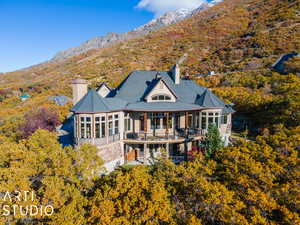 Back of house featuring a sunroom, a mountain view, and a balcony