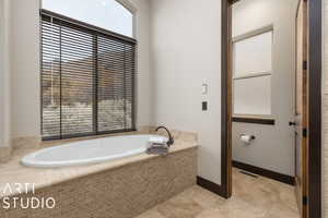 Bathroom with tiled bath and a wealth of natural light