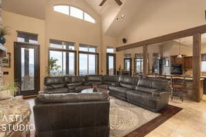 Tiled living room featuring ceiling fan and high vaulted ceiling