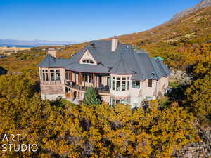 Rear view of property with a mountain view and a balcony