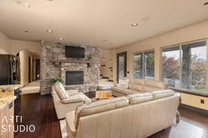 Living room with a fireplace and dark wood-type flooring