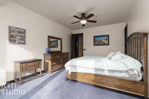 Carpeted bedroom featuring ceiling fan