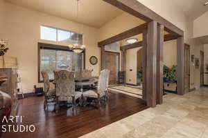 Dining room featuring light wood-type flooring, a high ceiling, and a chandelier