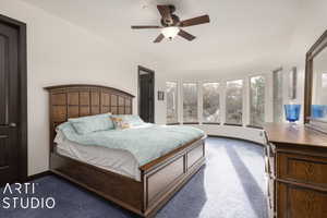 Bedroom with ceiling fan and dark carpet