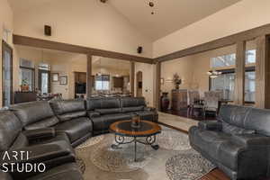 Living room with hardwood / wood-style floors, high vaulted ceiling, and plenty of natural light