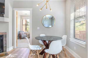 Dining space with a tiled fireplace and light wood-type flooring