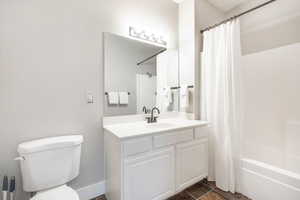 Full bathroom featuring shower / bath combo with shower curtain, vanity, and toilet