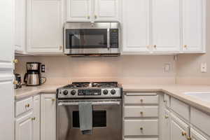 Kitchen with appliances with stainless steel finishes and white cabinetry