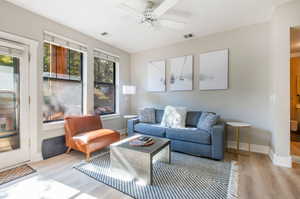 Living room with light hardwood / wood-style floors and ceiling fan