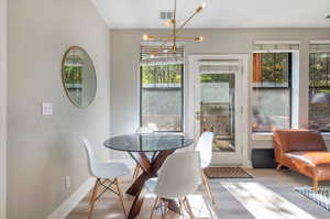 Dining area with a notable chandelier and light wood-type flooring