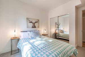 Bedroom featuring light carpet and a closet