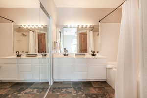 Bathroom with a shower with curtain and vanity