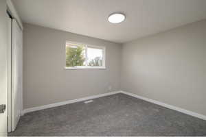 Spare room with dark colored carpet