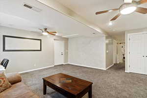 Living room with carpet flooring and ceiling fan