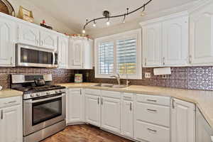 Kitchen with sink, white cabinets, and appliances with stainless steel finishes