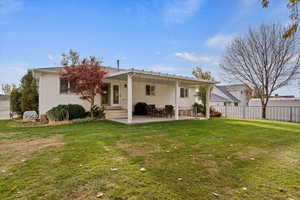 Back of property featuring a yard and a patio