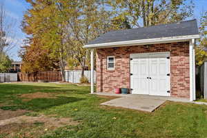 View of outbuilding featuring a lawn