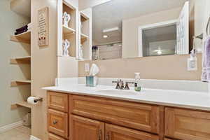 Bathroom with tile patterned floors, vanity, and a textured ceiling