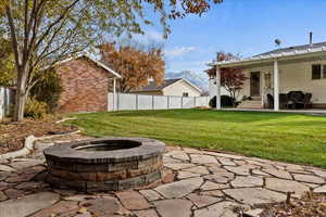 View of yard with a mountain view, a patio, and an outdoor fire pit