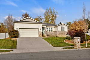 Ranch-style house featuring a garage and a front lawn