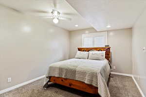 Bedroom with carpet flooring, ceiling fan, and a textured ceiling