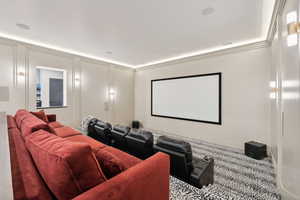 Cinema room featuring carpet and crown molding