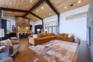 Living room featuring beam ceiling, dark hardwood flooring, wood ceiling, and high vaulted ceiling