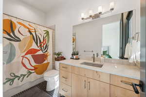 Full bathroom featuring tile patterned floors, vanity, shower / bath combo, and toilet