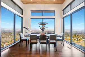 Dining space with dark hardwood floors, wood ceiling, and a wealth of natural light