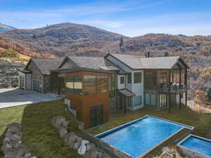 Rear view of house with a mountain view, a yard, and a balcony