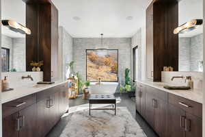 Bathroom featuring a bathing tub, tile patterned flooring, vanity, and tile walls