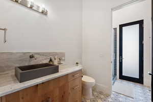 Bathroom featuring vanity, an enclosed shower, and toilet