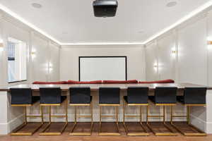 Home theater room featuring hardwood / wood-style floors and ornamental molding