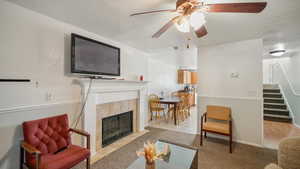 Tiled living room with ceiling fan and a tiled fireplace