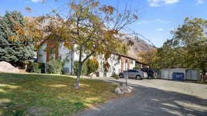 View of front of property featuring a mountain view, an outbuilding, and a front lawn