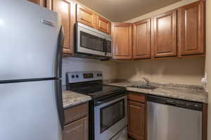 Kitchen with sink and appliances with stainless steel finishes