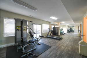 Workout area with dark hardwood / wood-style flooring and a textured ceiling