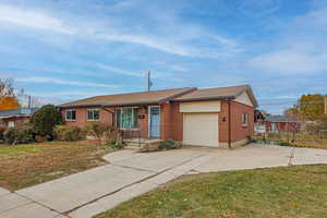 Ranch-style home featuring a garage and a front yard