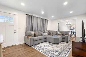 Living room with hardwood / wood-style floors and an inviting chandelier