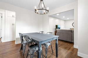 Dining room featuring dark hardwood / wood-style flooring and a notable chandelier