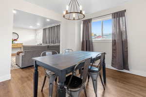 Dining area featuring wood-type flooring and an inviting chandelier