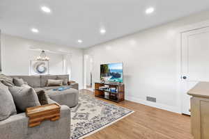 Living room featuring an inviting chandelier and light wood-type flooring